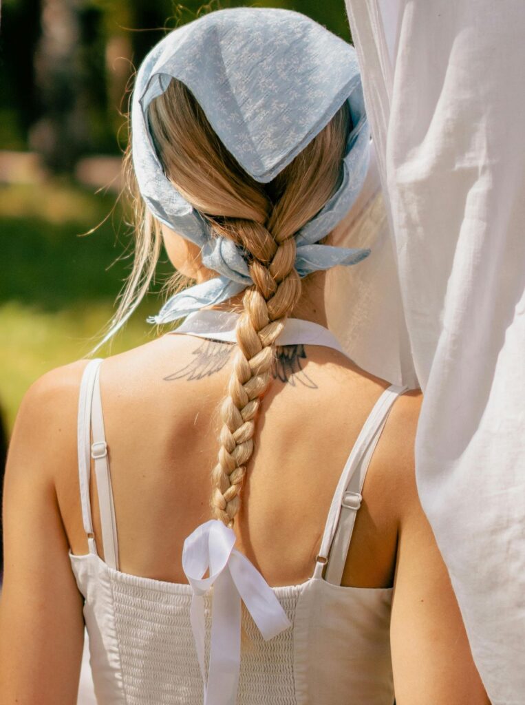 woman wearing blue headscarf and braid tied with white ribbon