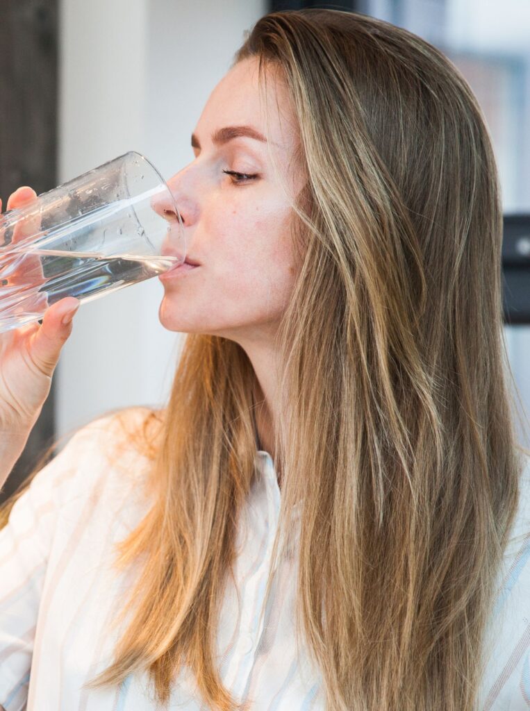 woman drinking water from glass
