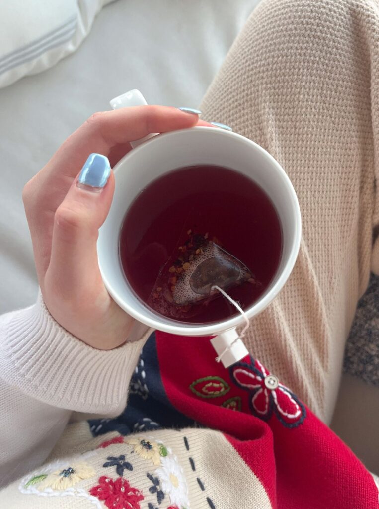 hand holding tea cup with tea bag in it