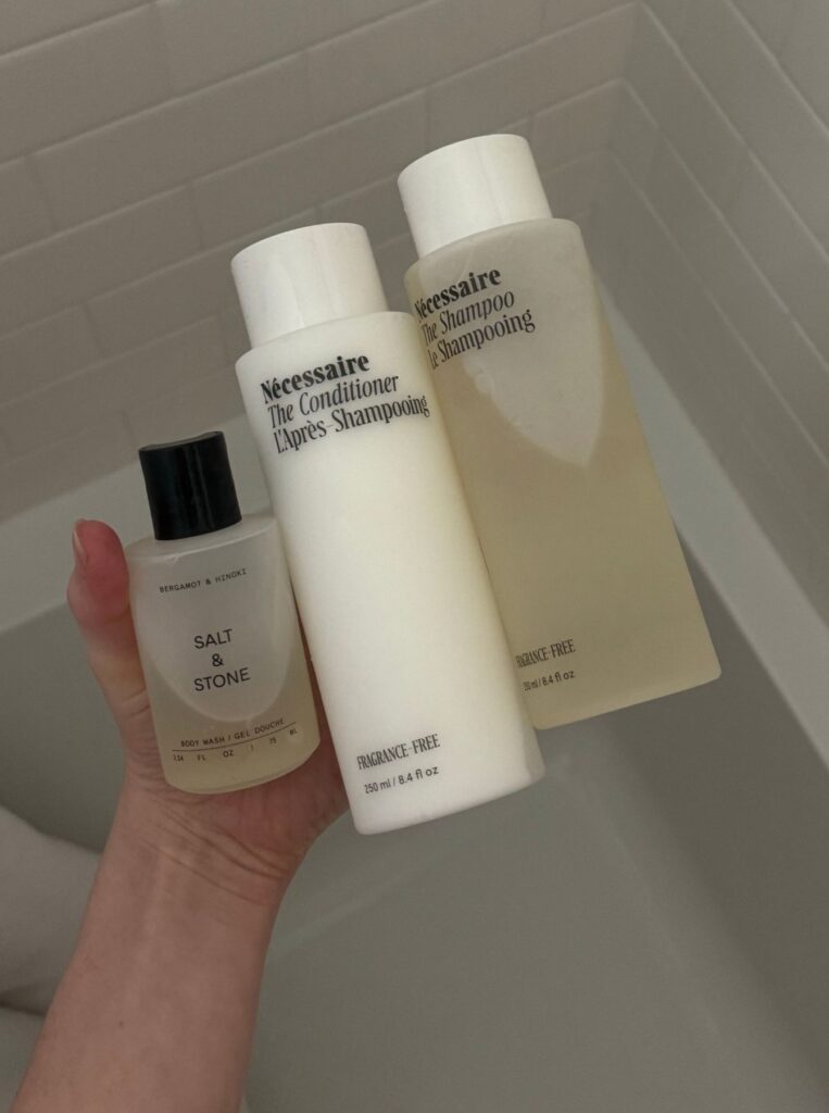 holding shampoo bottles over a bathtub